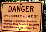 sign that says danger river closed to all vessels