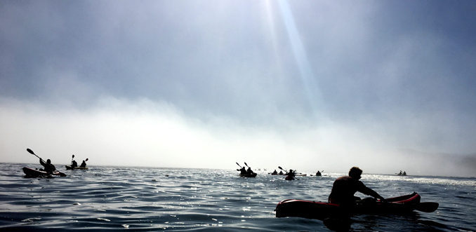kayakers in a fog bakayakers in a fog bank with sun streaming down photo by Alan Ahlstrand