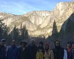 12 people in a line with Yosemite Fall in background