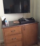 dresser with television above on wall