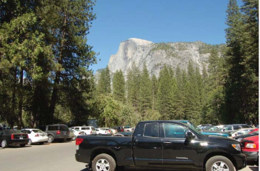 cars in parking lot with Half Dome beyond