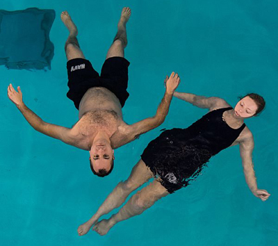2 people floating, one has legs sinking slightly