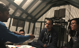 people playing poker in a canvas walled tent cabin