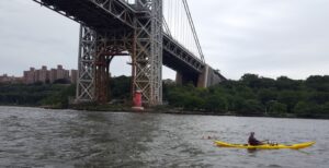 swimmer and kayaker under bridge