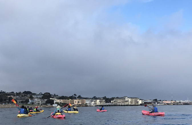 kayakers with clouds and blue sky above them