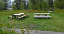 picnic tables with river behind