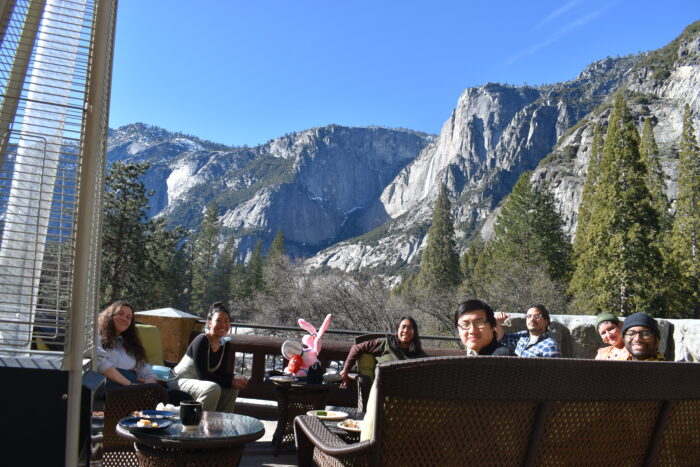 people sitting on balcony with Yosemite falls in background