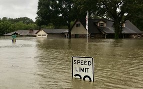 speed limit sign mostly submerged in floodwaters