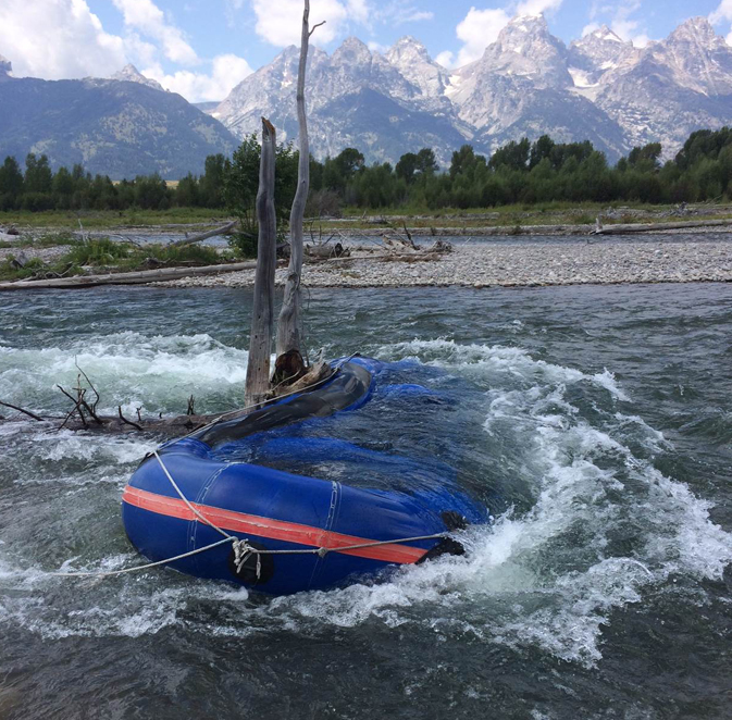 overturned raft stuck on a snag in river