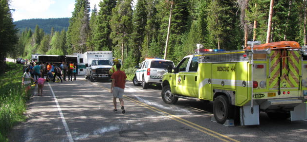 emergency vehicles and tour bus on its side tour bus on its side