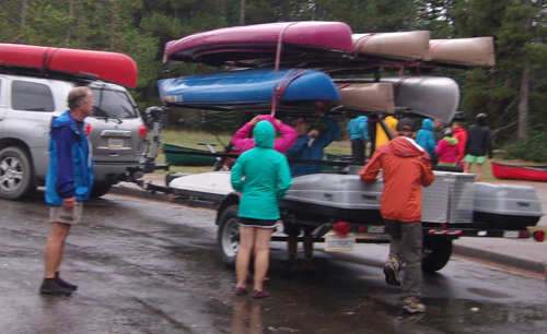 people working on loading kayaks on trailer