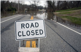 sign on flooded road says road closed