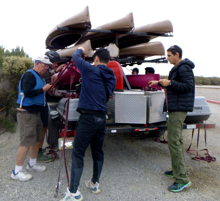 people at trailer untangling straps