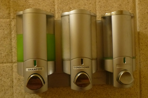three dispensers on shower wall, one with no label