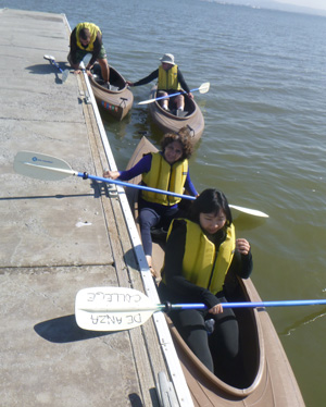 three kayaks at dock, one person climbing out