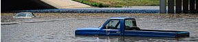 truck and car in deep water on roadway