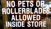 signs says no pets or rollerblades allowed inside store.