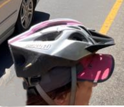 bike helmet loosely on head over a baseball cap