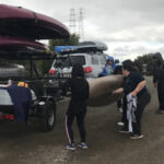 people lifting up a kayak off the ground