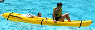 woman sitting in kayak,man in water holding on to side of kayak