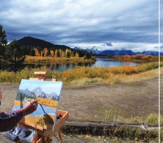 painter in foreground, mountains in back ground