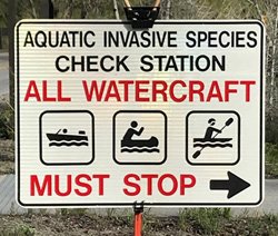 sign says Aquatic Invasive species check station all watercraft must stop