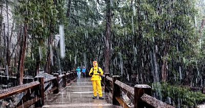man standing on a bridge in heavy rain snow mix