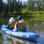 two women in kayak watch elk family