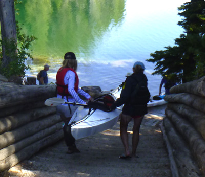 two people lifting kayak down a set of stairs