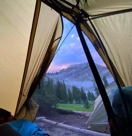 looking at mountains through open tent door