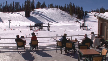 people sitting on deck overlooking ski area