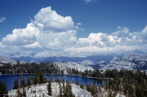 lake below mountains and clouds