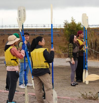 people standing holding paddles