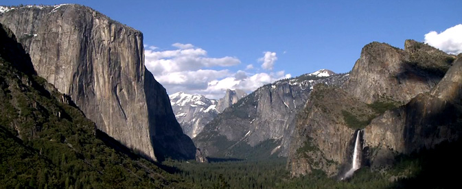 wide valley with waterfall and massive cliffs