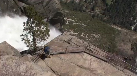 railing looks down at top of waterfall