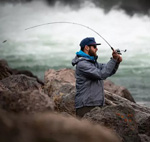 man fly casting with dam runoff behind