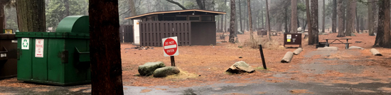 campsite with dumpsters and restroom next to it