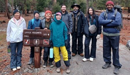 hikers and trail sign that says upper yosemite fall