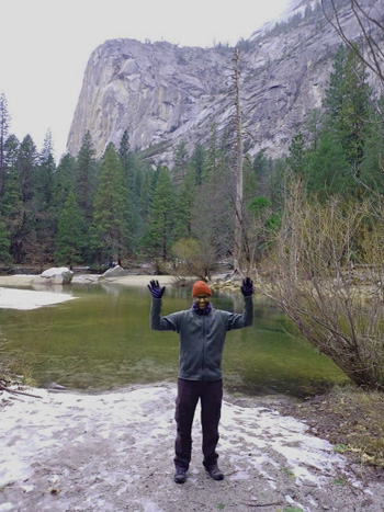 man standing with hands up in air, arms bent at elbow