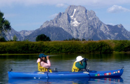 two people in a kayak wearing hats with large brims