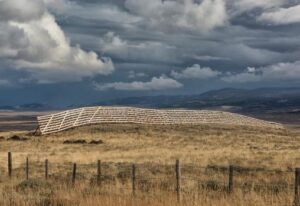 livestock fence in foreground, taller snow fence behind