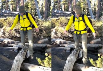 man crossing a creek by stepping on logs