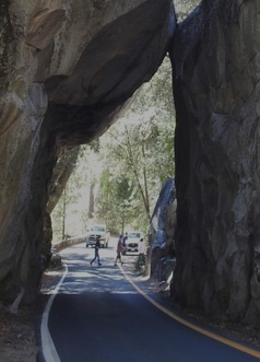 view of people on roadway beyond a tunnel