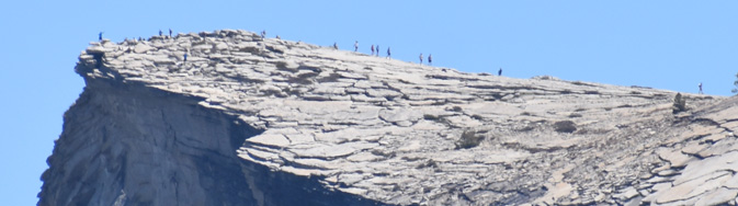 line of barely visible people on top of mountain