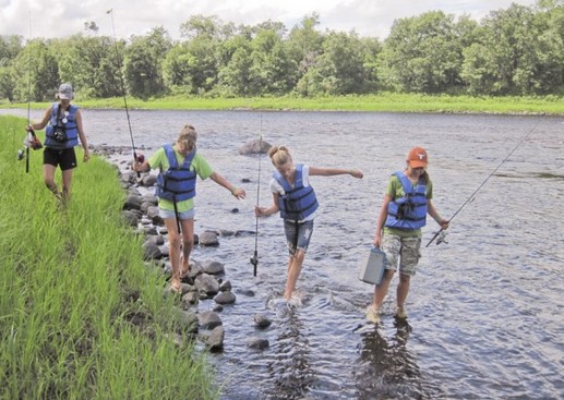 people wading in a river wearing lifejackets