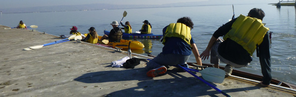 climbing into a kayak on a dock