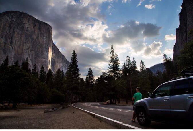 man leaning on car looking at view