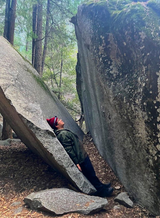 man lying on a near vertical granite slab