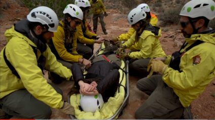 team of rescuers prepares a litter with a person it