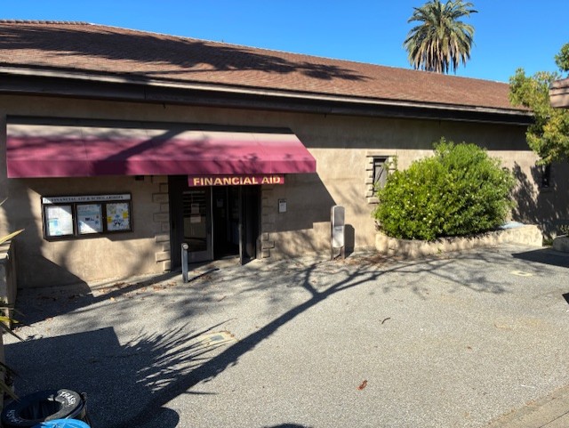 side of a building with a red canopy over the door to the De Anza college Financial Aid office 
